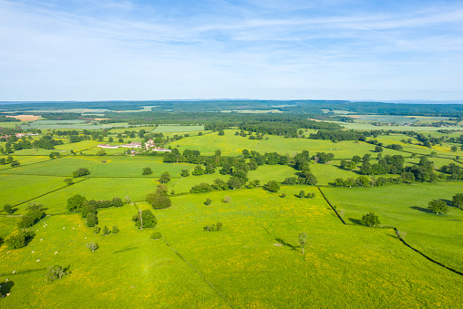 This landscape photo was taken in Europe, in France, in Burgundy, in Nievre, in Cuncy les Varzy, towards Clamecy, in Spring. We see a French village in the green countryside, under the Sun.