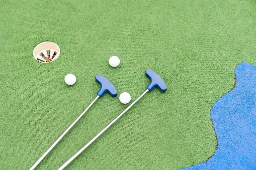 Golf stick and ball on green grass close up. High quality photo