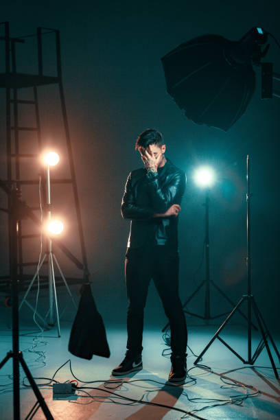 istock Portrait of young caucasian handsome man in studio with dramatic light 1929790305