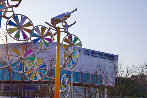 Sangju City, South Korea - March 9, 2017: Artistic sculptures adorning the vicinity of Sangju Bicycle Museum, showcasing a blend of cultural art and cycling heritage with the museum structure in the background.