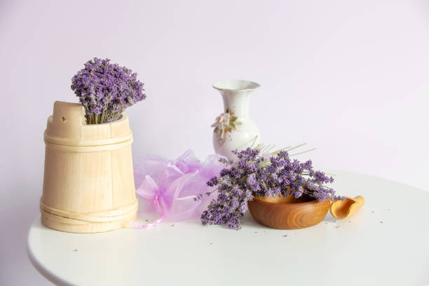 Bouquets of lavender flowers and wooden decor and organza sachet bags still-life on white table background, provence style