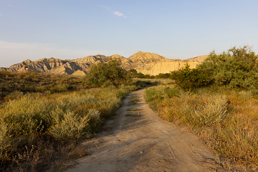 Dirt road desert landscape in Vashlovani national park mountains of Georgia with dry nature at sunset