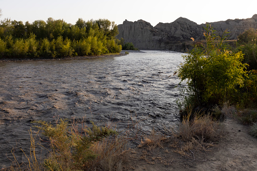 Alazani river in Vashlovani national park in Georgia with dry mountains and desert landscape at sunset