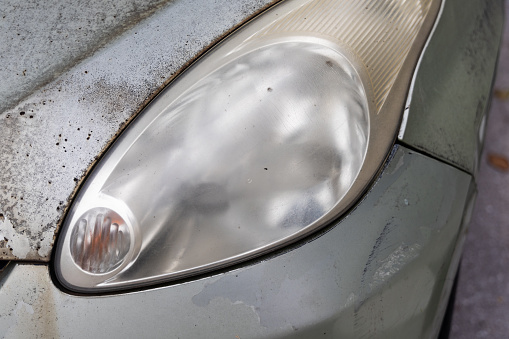 Hazy opaque foggy front head lamp of car reduces light pass-through and driving visibility on the road