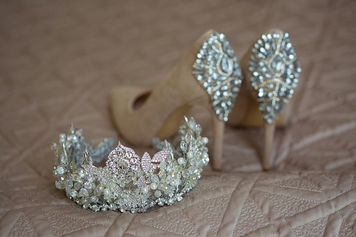 A luxurious tiara for a bride or princess close-up. Shoes in the background. Jewelry accessories. Selective focus.