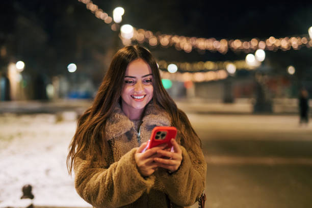 istock Young beautiful woman using smart phone while in the city 1929836798