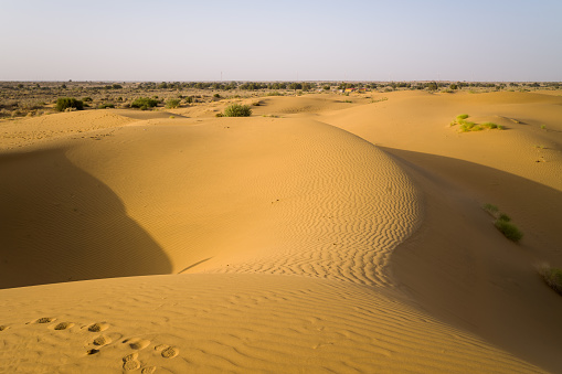 This landscape photo was taken in Asia, India, Rajasthan, Jaisalmer, Summer. We see The desert, under the Sun.