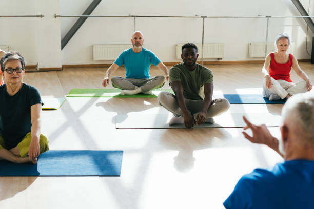 istock Group of senior athletes raise hands to ceiling at workout 1929853138