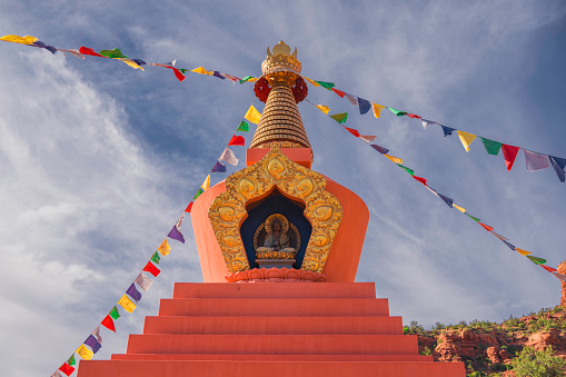 This image shows an authentic buddhist stupa with a calm blue sky in the background.