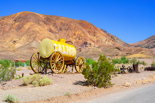 Calico Ghost Town, California, United States - August 31, 2023: Yellow painted water wagon along the road to Calico Ghost Town, California.