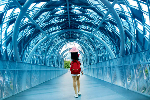istock Young woman with backpack walking in pedestrian walkway tunnel 1929861774