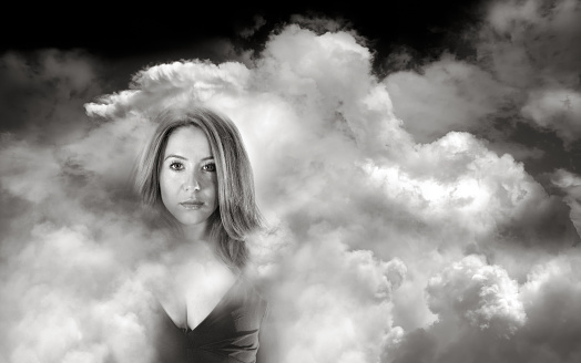 Solitude concept of beautiful white woman portrait with cloudy sky