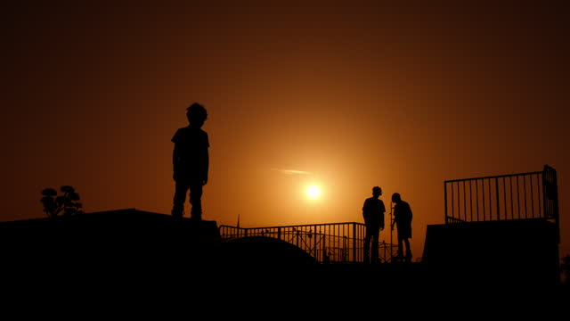 Silhouettes during skateboarder riding.