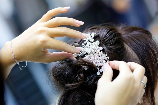 Hands dress up a luxurious tiara for a bride or princess close-up. Jewelry accessories. Selective focus.