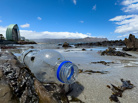 Empty plastic bottle rubbish pollution lying on the beach near beachfront