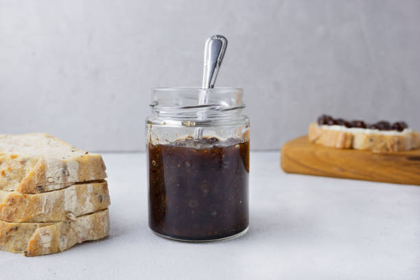 istock Strawberry jam in a glass jar on a light gray background with sliced bread. Composition with delicious homemade jam. Breakfast and snack concept. 1929874361