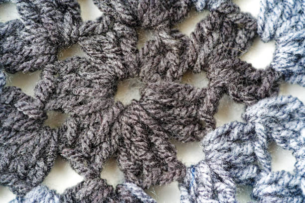 istock Top view of abstract crocheted pattern lying on white background. 1929875454