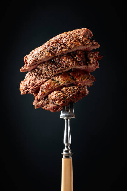 istock Grilled beef steak on a fork sprinkled with rosemary. 1929879200