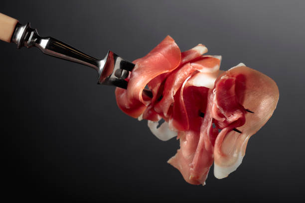 istock Slices of prosciutto on a fork. 1929880308