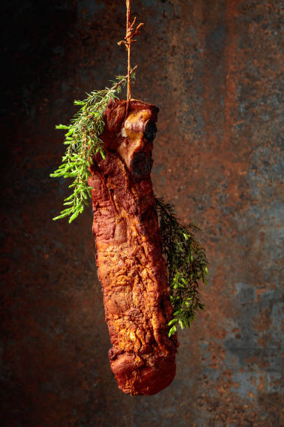 istock Smoked pork ribs with juniper branches on a rusty background. 1929880451
