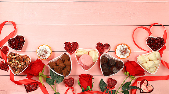 Gourmet heart shaped chocolate candies, sugar cranberry, meringue and rose flowers, food for Valentine's Day or Women's Day, greeting card, advertising banner or store invitation, selective focus