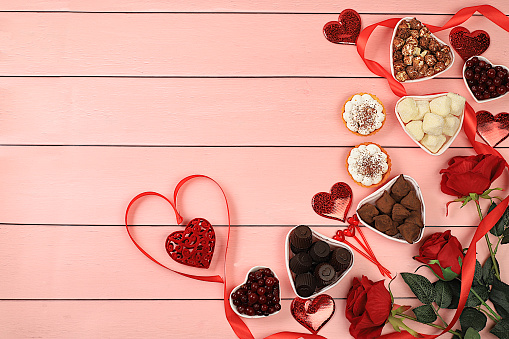 Gourmet heart shaped chocolate candies, sugar cranberry, meringue and rose flowers, food for Valentine's Day or Women's Day, greeting card, advertising banner or store invitation, selective focus