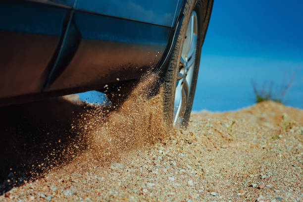 istock Car wheel slips on the sand in desert close-up view 1929884067
