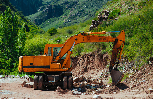 Crawler excavator in the quarry on mountains background