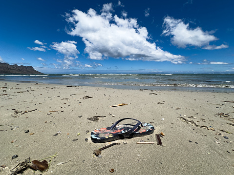 Abandoned Flip flop shoe lying on the beach