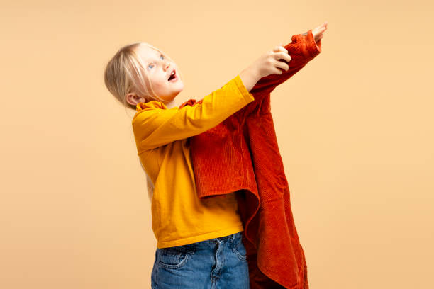 istock Cute focused little girl wearing brown jacket while preparing go to school 1929888235