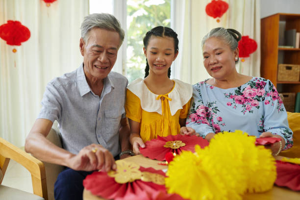 istock Grandparents Teaching Girl Making Decorations 1929889413