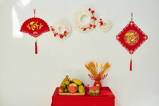 Vietnamese lunar new year decorations with ornaments hanging on wall and table with fresh fruits