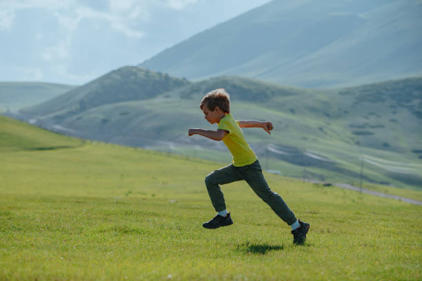 istock Boy running fast on a green meadow in the mountains 1929890929