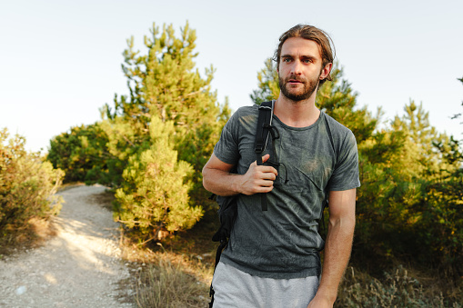 Portrait of hiker man with backpack trekking in the mountains close up