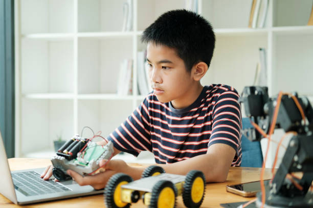 istock Asian teenager doing robot project in science classroom. technology of robotics programing and STEM education concept. 1929912104