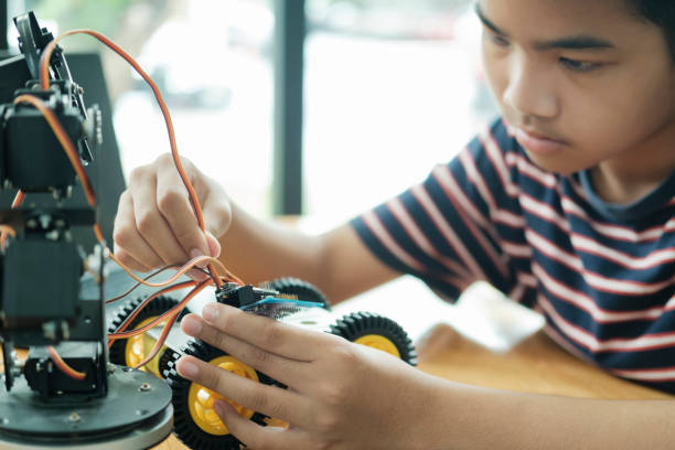 istock Asian teenager doing robot project in science classroom. technology of robotics programing and STEM education concept. 1929912258