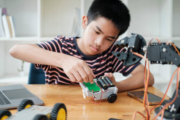 istock Asian teenager doing robot project in science classroom. technology of robotics programing and STEM education concept. 1929912277