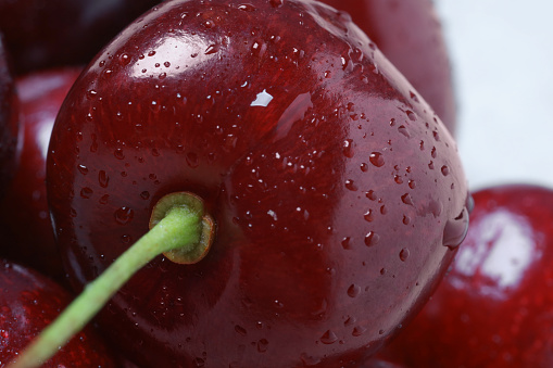 Cherry fruits fresh with dew water drops on dark gray moody background with shadows