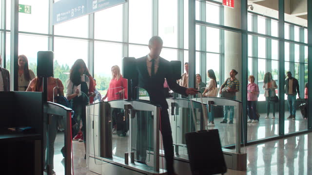 Multi-Ethnic Group of Tourists Entering By Self-Scanning Boarding Pass at Security Point of an Airport