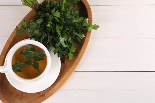 istock Aromatic herbal tea and fresh parsley on white wooden table, top view. Space for text 1929932575