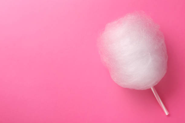 istock One sweet cotton candy on pink background, top view. Space for text 1929939416