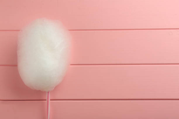 istock One sweet cotton candy on pink wooden table, top view. Space for text 1929939958