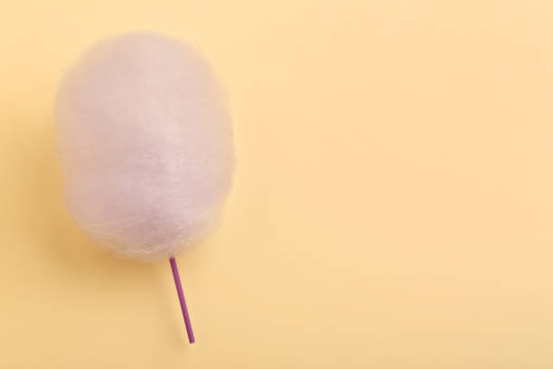 istock One sweet cotton candy on beige background, top view. Space for text 1929940502