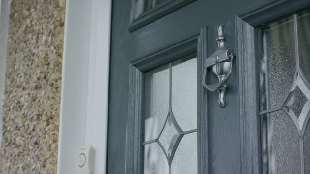 Closeup footage of adult male hand using the door knocker to knock the door
