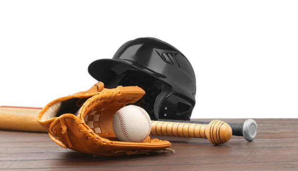 istock Baseball glove, bats, ball and batting helmet on wooden table against white background 1929952985