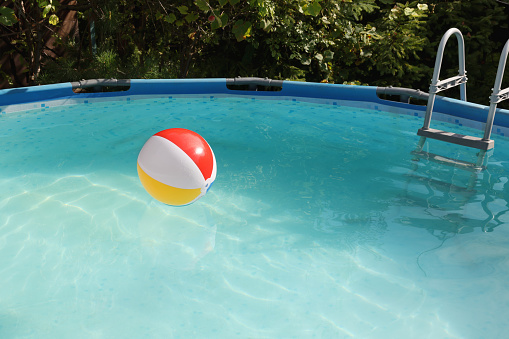 Inflatable ball on water in above ground swimming pool outdoors