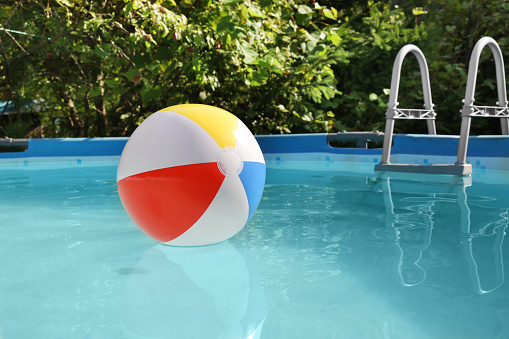 Inflatable ball on water in above ground swimming pool outdoors
