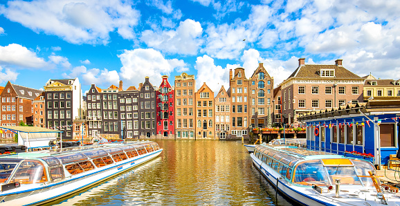 Amsterdam city skyline and colorful dancing houses over Damrak canal, Netherlands travel photo