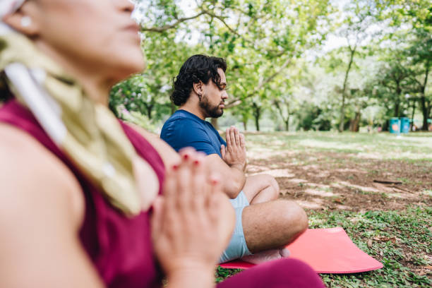 istock Couple doing yoga at park 1929972586