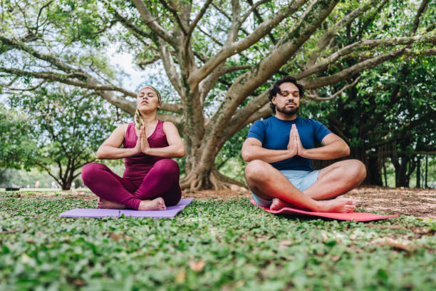 istock Couple meditating at park 1929972590